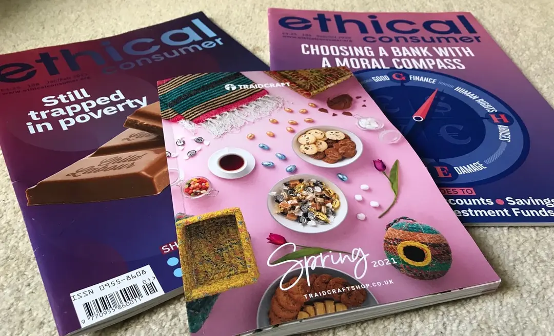 Copies of Ethical Consumer magazine and a Traidcraft catalogue laid out on a carpet.